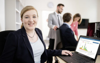 Lächelnde Frau vor dem Laptop