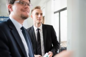 Zwei Personen, die auf eine für den Betrachter nicht sichtbare Wand schauen