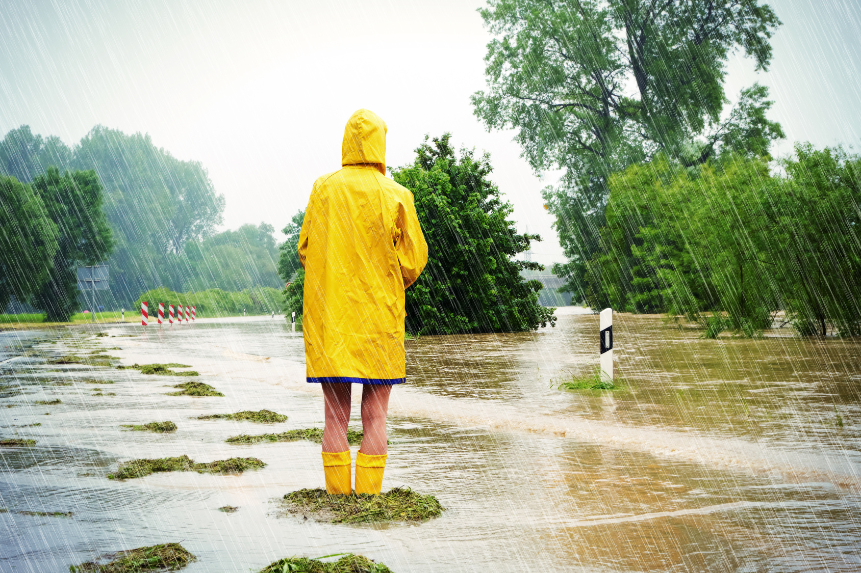 Person steht bis zu den Knien in Regenwasser.